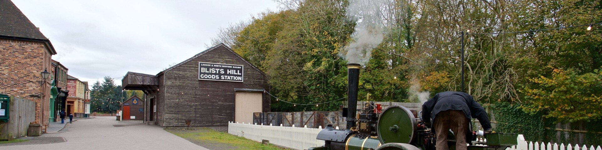 A steam locomotive at a goods station with a brick building labeled "Blists Hill Goods Station."