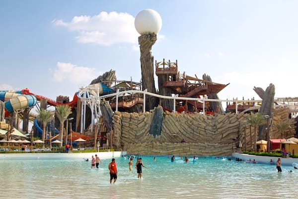 Un parc aquatique doté d’une grande piscine à vagues, d’un toboggan aquatique et d’une structure rocheuse.