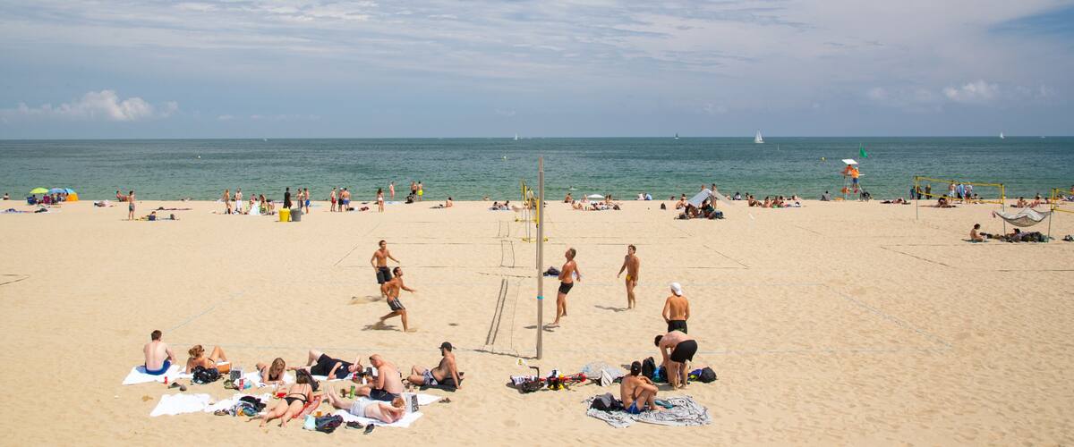 Bogatell Beach which includes general coastal views and a sandy beach as well as a small group of people