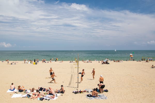 Bogatell Beach which includes general coastal views and a sandy beach as well as a small group of people