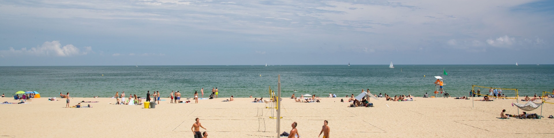 Bogatell Beach which includes general coastal views and a sandy beach as well as a small group of people