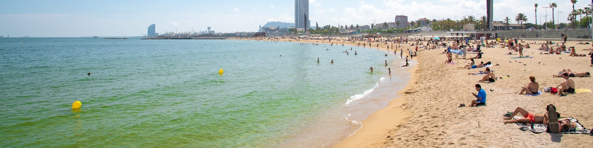 Bogatell Beach which includes a sandy beach and general coastal views as well as a small group of people