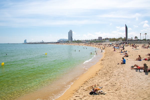 Bogatell Beach which includes a sandy beach and general coastal views as well as a small group of people