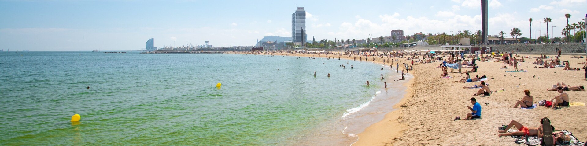 Bogatell Beach which includes a sandy beach and general coastal views as well as a small group of people