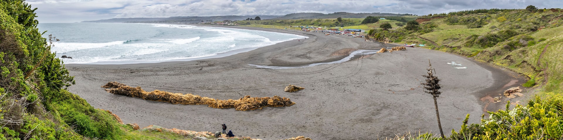 La Rinconada Beach close to Cobquecura town is a wild beach with a wonderful scenery. Big waves approaches the coast and impact to the sand dunes on the beach where the fishermen boats wait. Chile