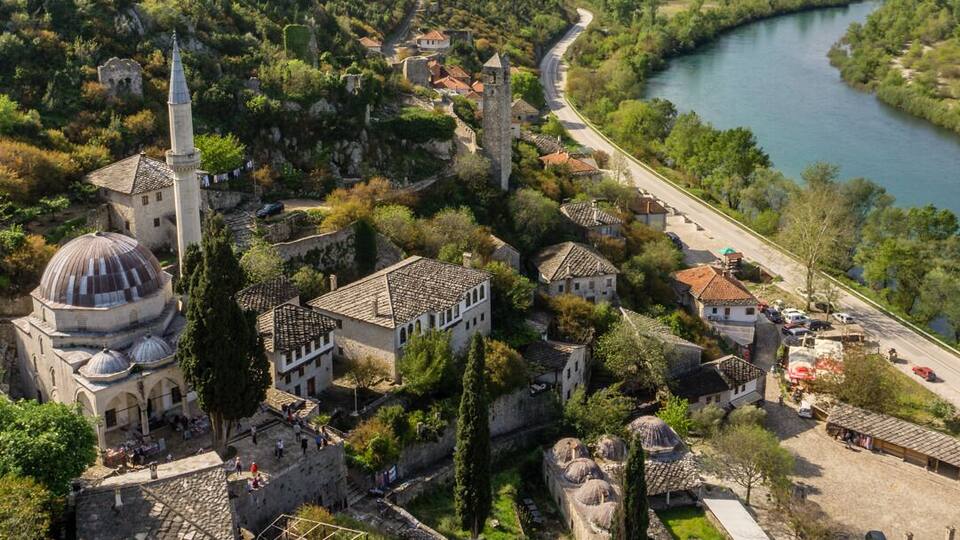 A historic town with a river, a prominent church, and a castle on a hill.