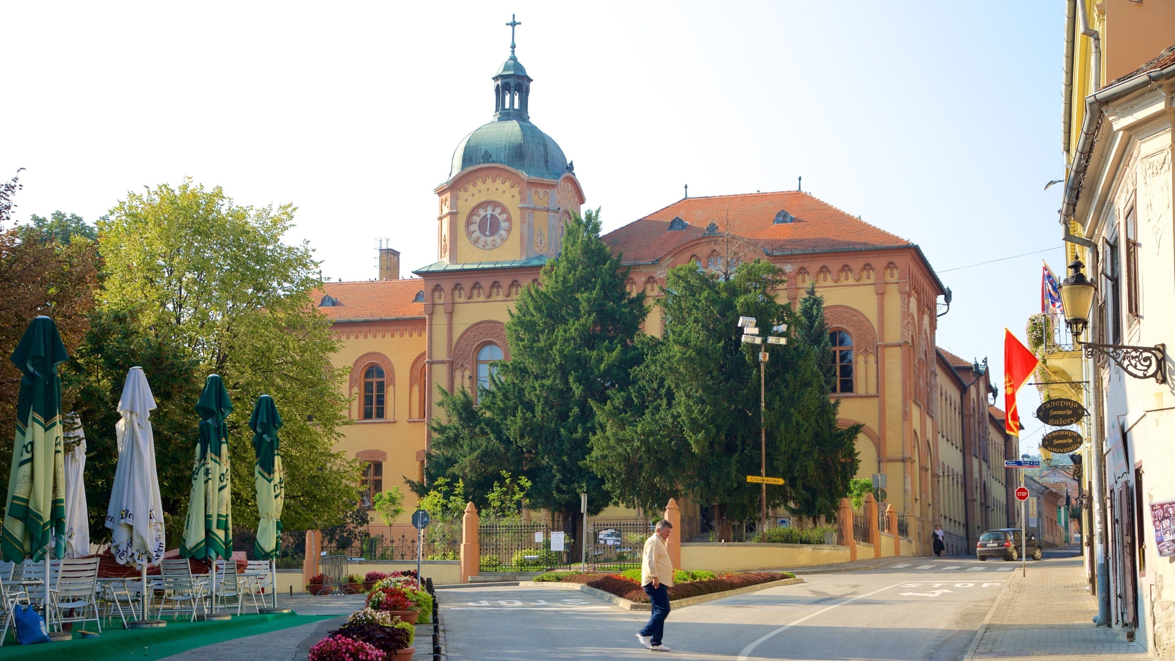 A street with a church, outdoor seating, and a pedestrian crossing.