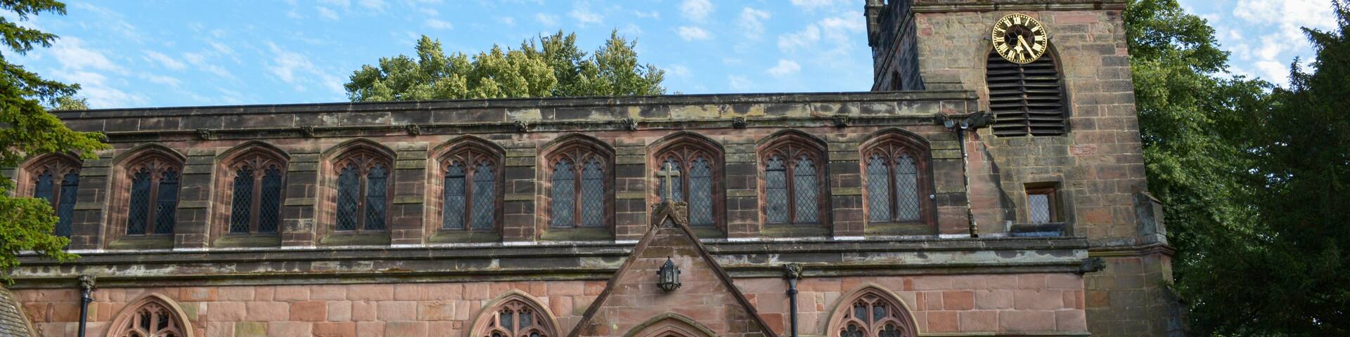 A historic church with a clock tower, arched windows, and a stone facade.