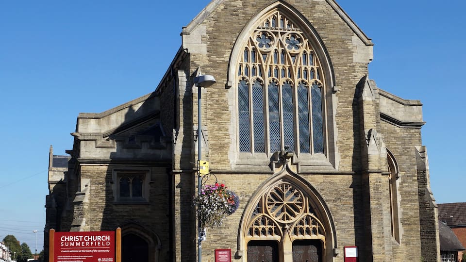 Una iglesia histórica con arquitectura gótica, que presenta arcos apuntados y vidrieras.