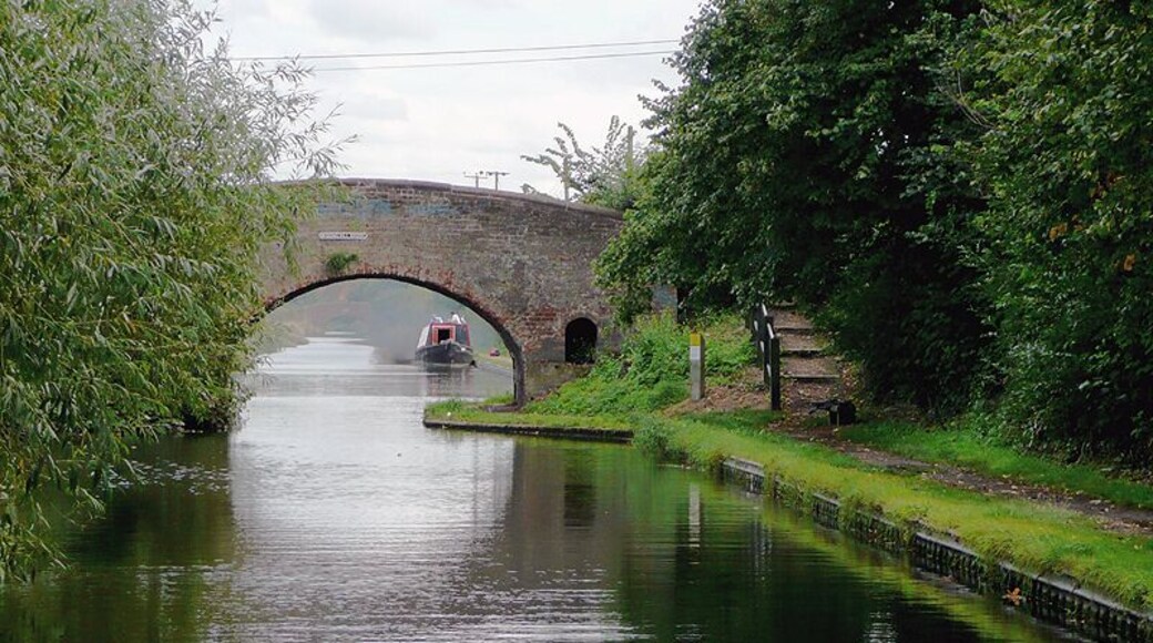 Wiggins Hill Bridge near Curdworth, Warwickshire Birmingham and Fazeley Canal. The original purpose of this canal was to provide a link between Birmingham and the south east of England, by way of the Coventry Canal and the Oxford Canal. John Smeaton was the engineer, and the canal was completed in 1789. The moored narrowboat beyond the bridge is having engine problems, and has just blown out an almighty cloud of murky smoke! The bridge carries Wiggins Hill Road from the A4097 (to the right) to Over Green and Grove End.