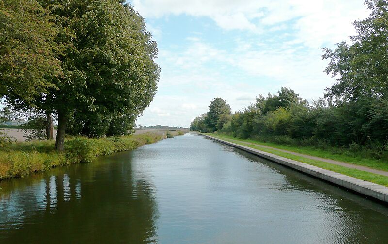 Birmingham and Fazeley Canal near Minworth, Birmingham Here the canal is leaving the built up part of Birmingham and approaches Curdworth through flat farm land. There are still some recently built factory units and a sewage works to the south (right) of the canal. The original purpose of this canal was to provide a link between Birmingham and the south east of England, by way of the Coventry Canal and the Oxford Canal. John Smeaton was the engineer, and the canal was completed in 1789. The canal now runs from the BCN Main Line at Old Turn Junction, Birmingham to the Coventry Canal at Fazeley Junction, just outside Tamworth. The length is 15 miles (24 km), and it includes 38 locks. There is also a short branch to Digbeth, Birmingham. Information from Wiki Birmingham_and_Fazeley_Canal .