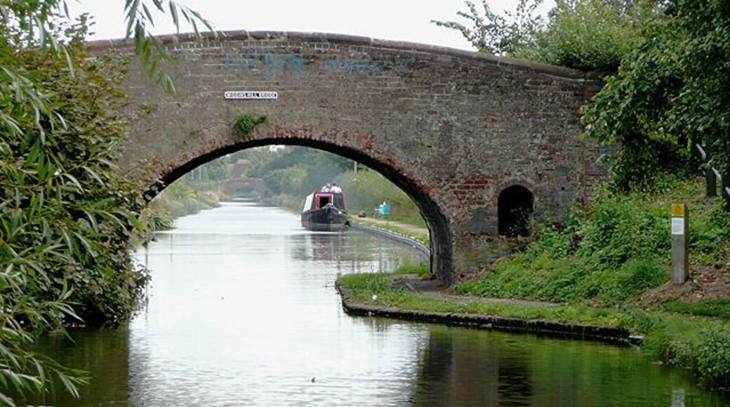 Wiggins Hill Bridge near Curdworth, Warwickshire Birmingham and Fazeley Canal. The original purpose of this canal was to provide a link between Birmingham and the south east of England, by way of the Coventry Canal and the Oxford Canal. John Smeaton was the engineer, and the canal was completed in 1789. The bridge carries Wiggins Hill Road from the A4097 (which is to the right) to Over Green and Grove End.