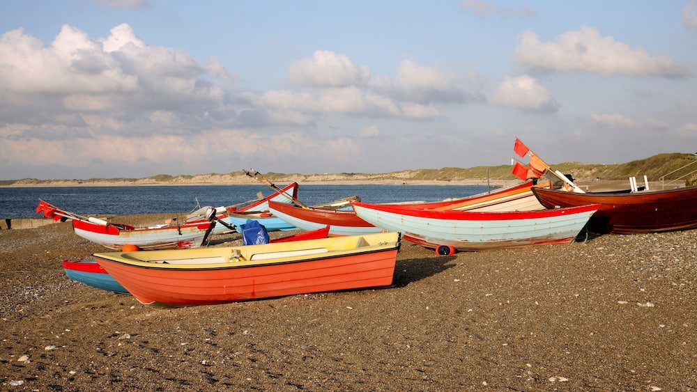 Coloured fishing boats pulled up on the beach at Klitmoeller on the west coast of Jutland, Denmark.