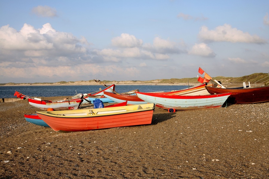 Coloured fishing boats pulled up on the beach at Klitmoeller on the west coast of Jutland, Denmark.
