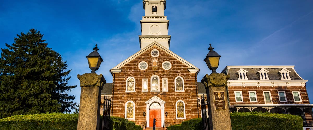 A church with a tall steeple, a large wooden door, and a clock tower.
