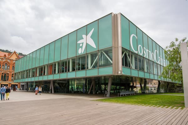 Ein modernes Gebäude mit einer großen Glasfassade und dem Schriftzug "CosmoCasa" darauf.