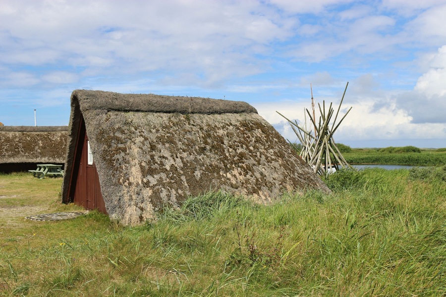 Old fisher hut with thatched roof in Denmark, Europe. In the town Nymindegab, next to west coast and the Ringkobing Fjord.