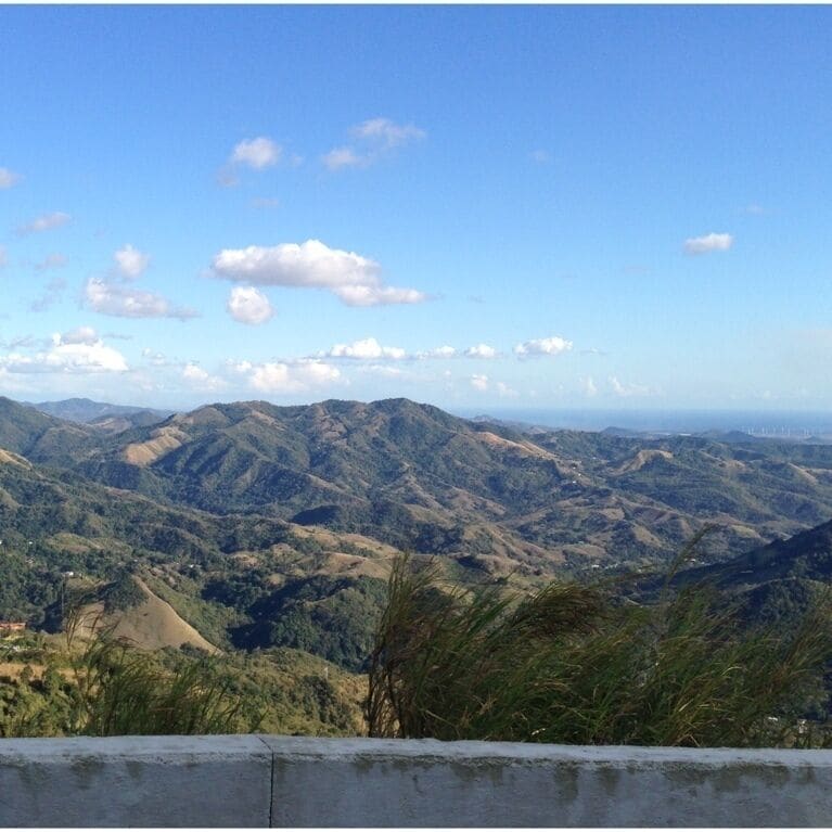 A mountainous landscape with rolling hills and scattered clouds.