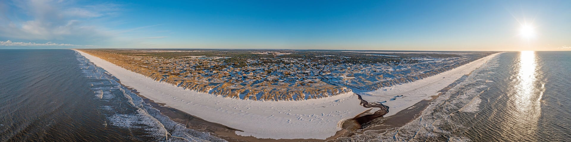 Drone panorama over Vejers beach in Denmark with sunshine and snow