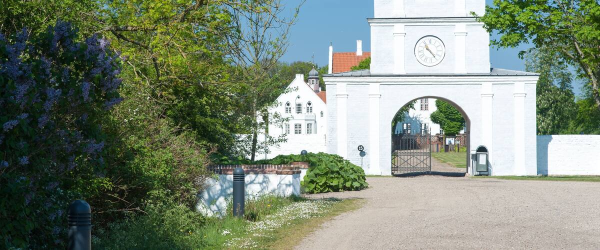 A white building with a clock tower and an arched entrance.