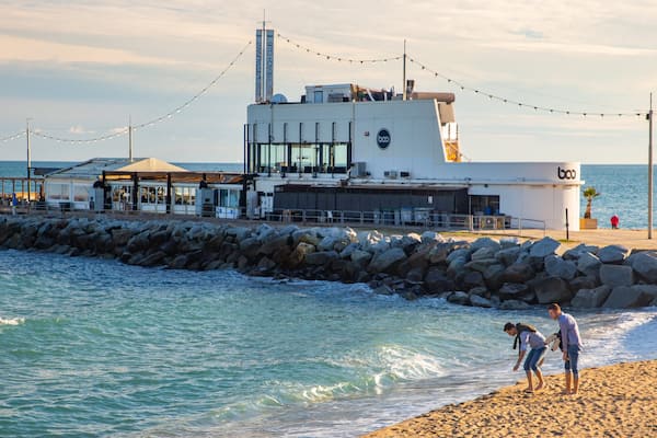 Mar Bella Beach which includes general coastal views and a beach as well as a couple