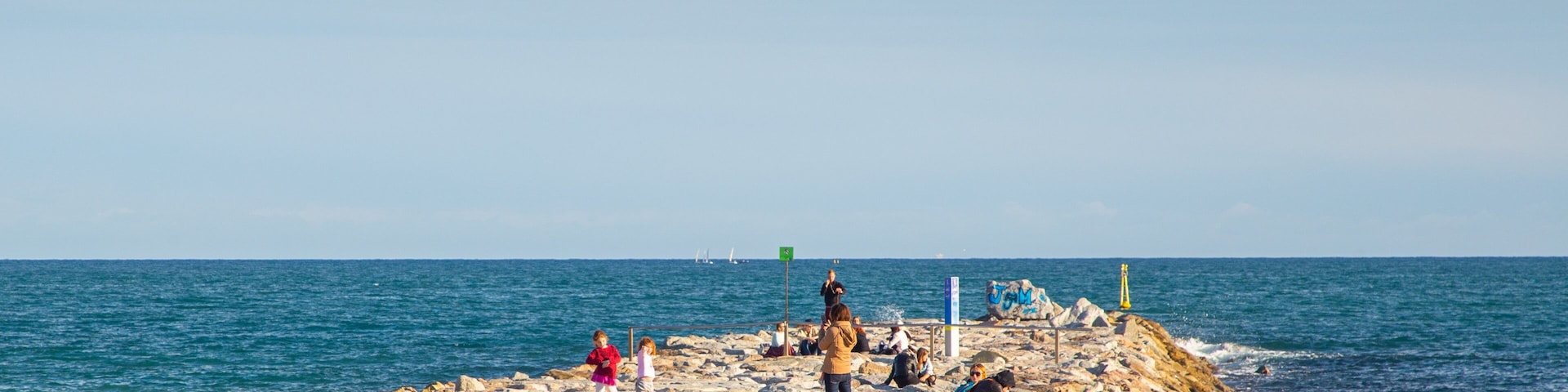 Mar Bella Beach featuring general coastal views and a sandy beach as well as a small group of people