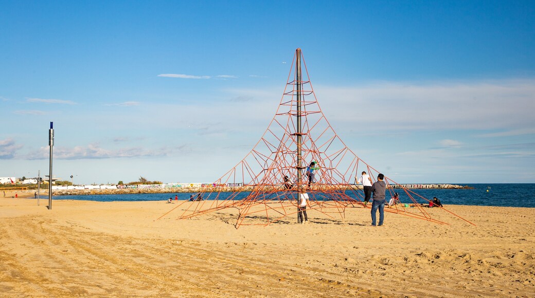 Mar Bella Beach featuring a playground and a sandy beach as well as a family