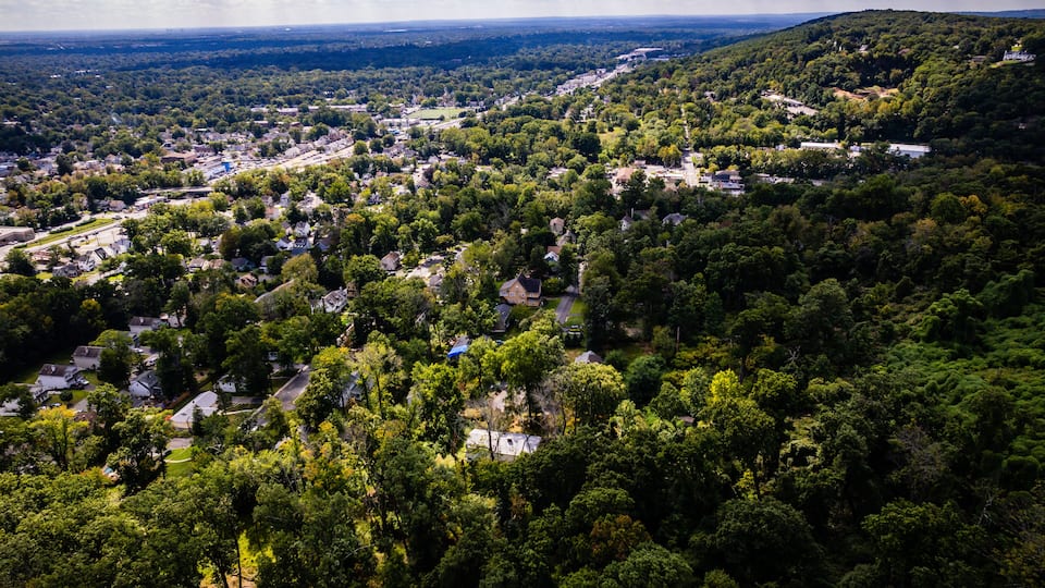 A town nestled in a valley surrounded by dense forests and hills.