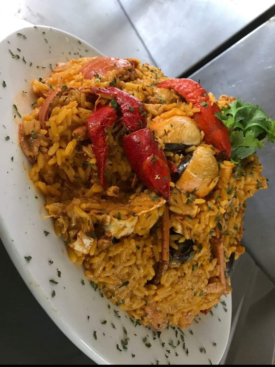 A plate of seafood paella with red peppers and mussels.