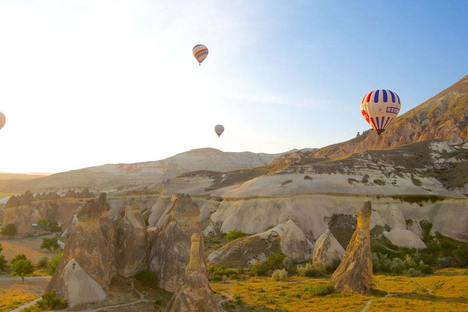 Paisaje con formaciones rocosas únicas y globos aerostáticos.