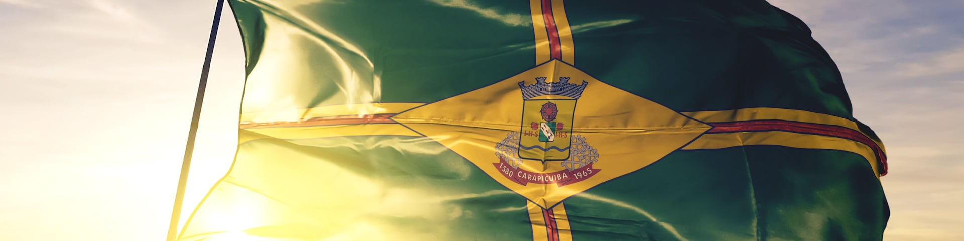 Carapicuiba of Brazil flag waving on the top sunrise mist fog