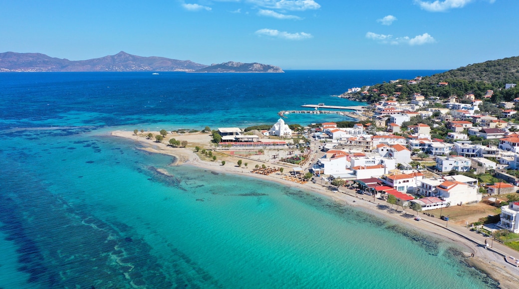 Aerial drone photo of iconic picturesque village, main port and beautiful turquoise beaches of Skala featuring landmark church of Agioi Anargiroi, Agistri island, Saronic gulf, Greece