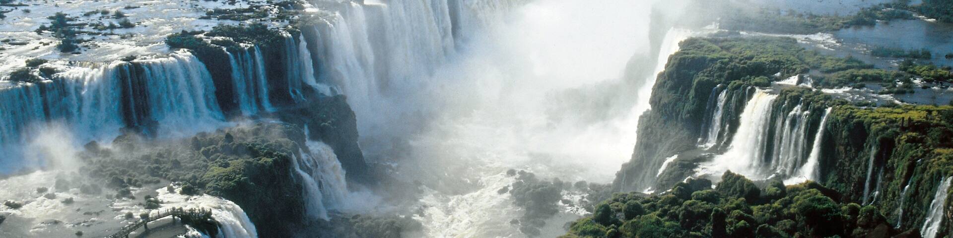 A large waterfall with multiple cascades surrounded by dense greenery.