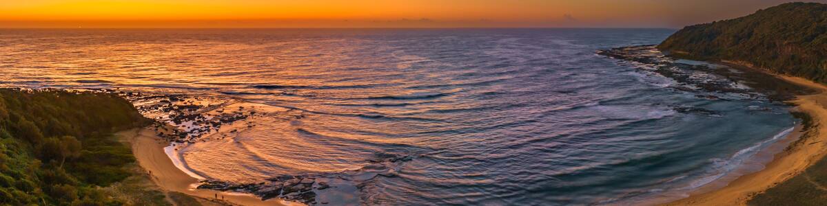 Aerial sunrise seascape panorama with beach and clear skies