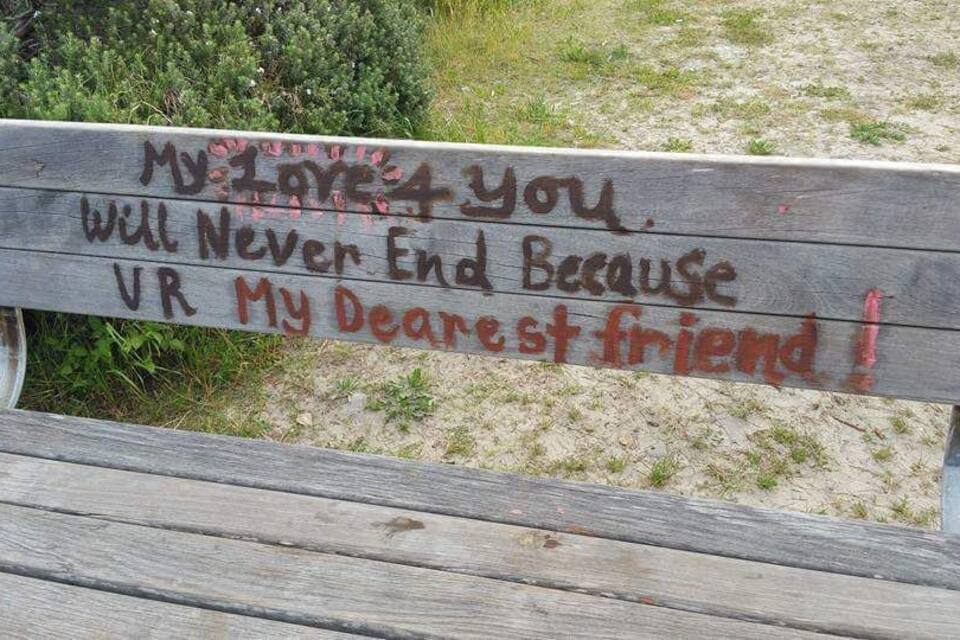 A wooden bench with graffiti that reads "My favorite you will never end because VR my dearest friend!"