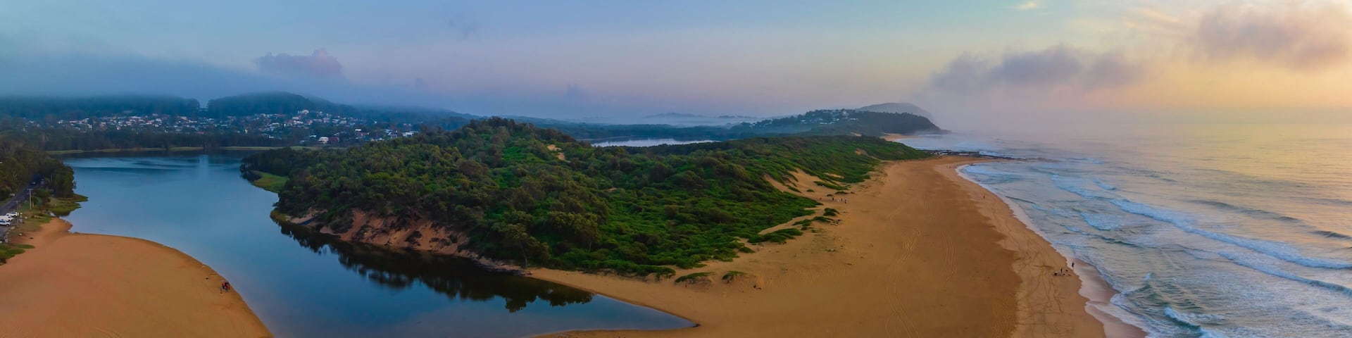Summer sunrise panorama at the beach and lagoon with clouds and haze