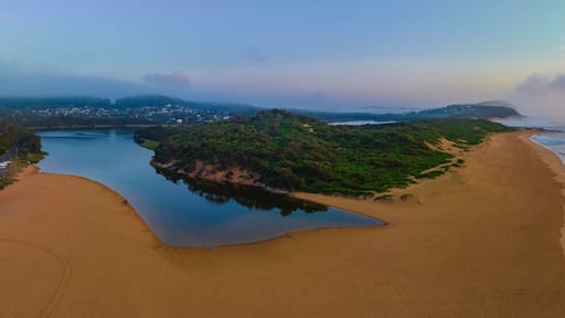 Summer sunrise panorama at the beach and lagoon with clouds and haze