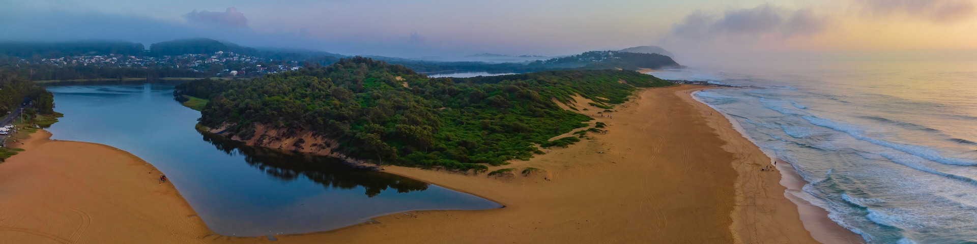 Summer sunrise panorama at the beach and lagoon with clouds and haze
