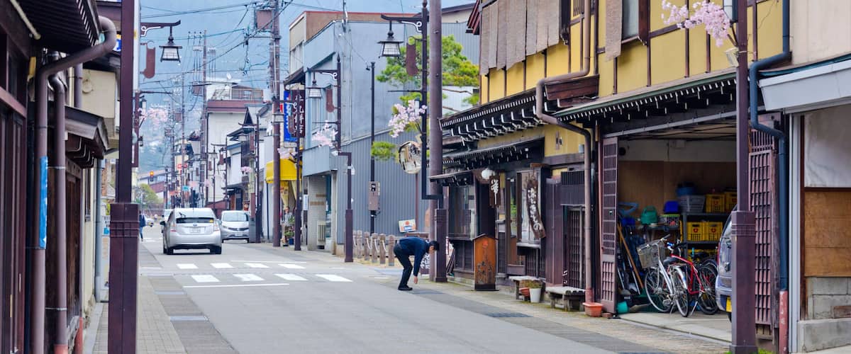 A street with traditional architecture, a parked bicycle, and a car.