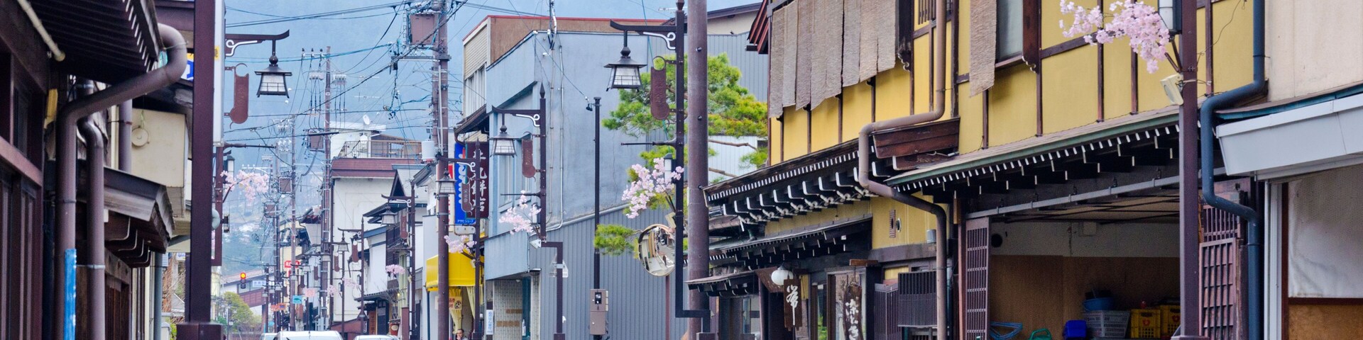 A street with traditional architecture, a parked bicycle, and a car.