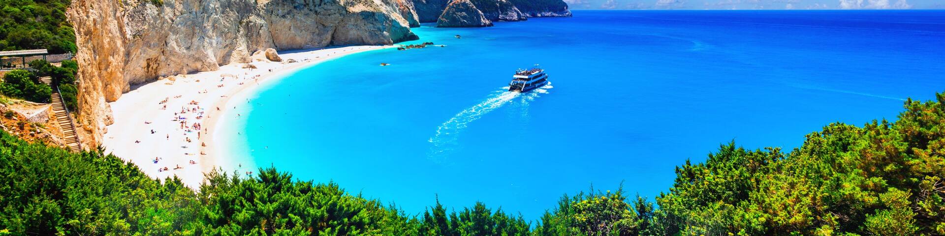 Ultra-wide high resolution panorama of Porto Katsiki beach, Lefkada. view of white cliffs, excursion boat and turquoise Ionian sea in Greece.