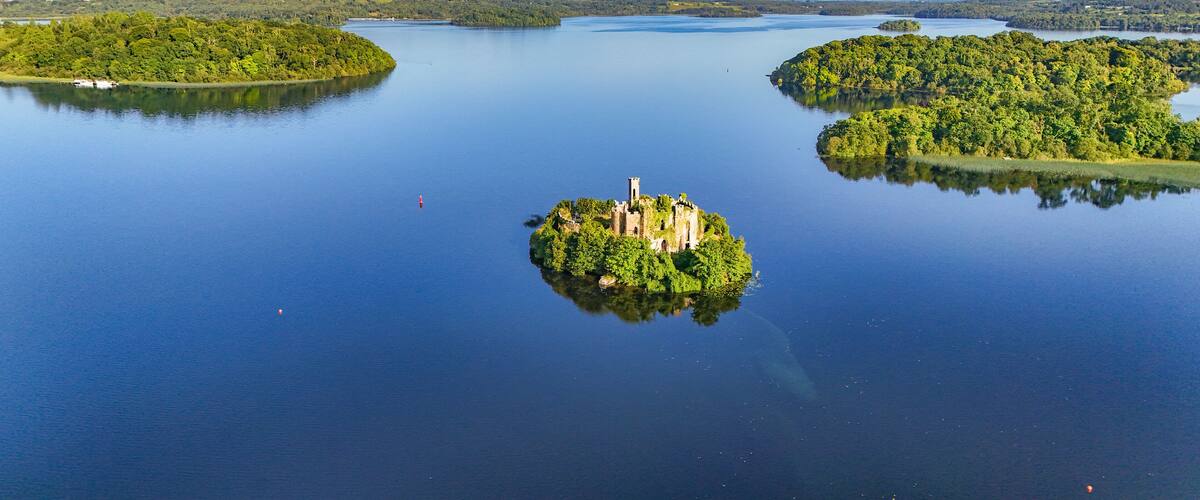 A large lake with three small islands, one of which has a castle ruin.