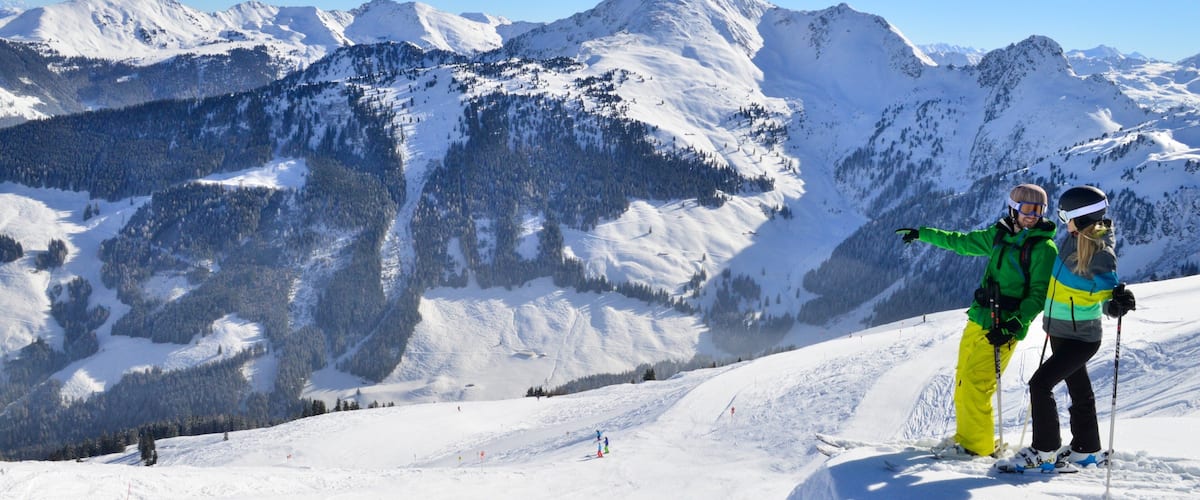 A snowy mountain landscape with skiers.