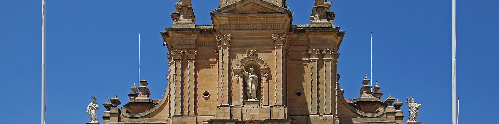 A historic church with a bell tower, ornate facade, and statues.