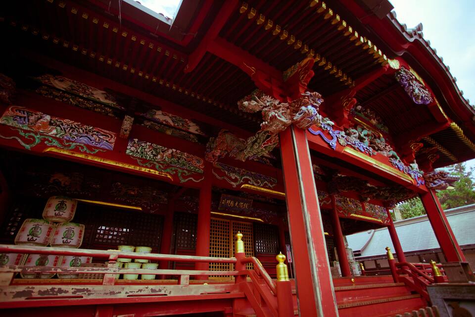 A traditional red temple with ornate decorations and golden accents.