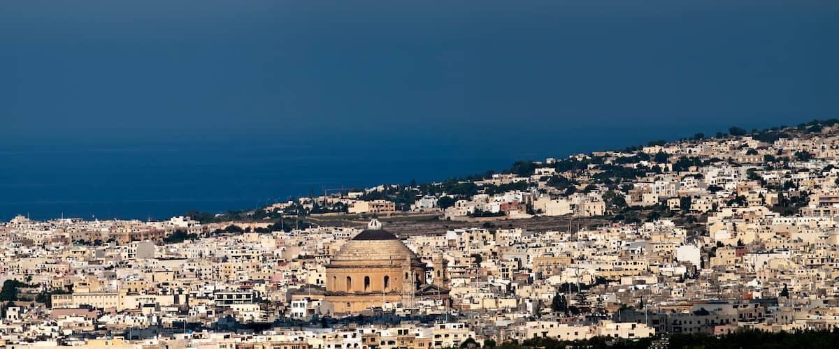 A coastal cityscape with a prominent historical building in the center.