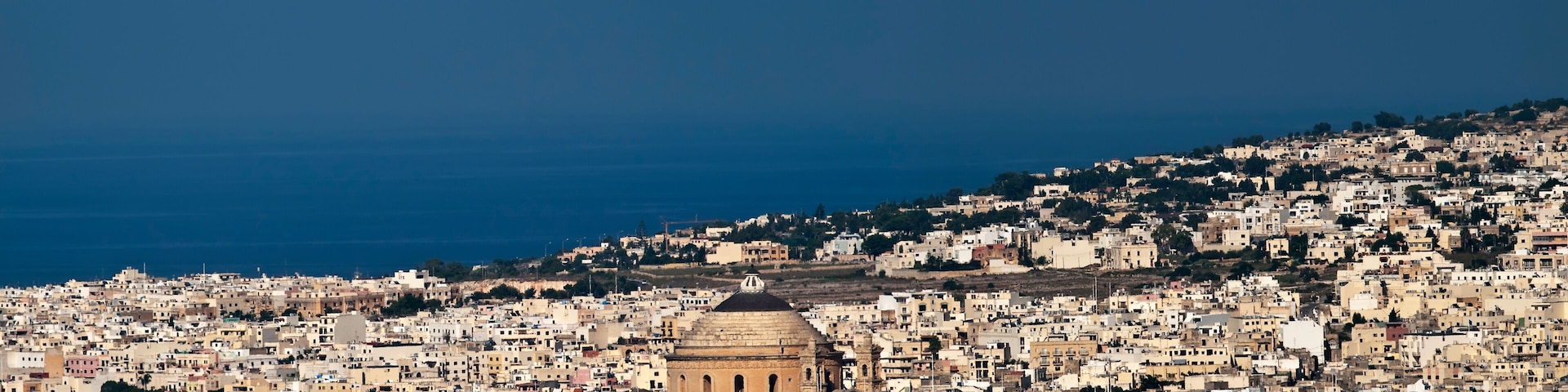 A coastal cityscape with a prominent historical building in the center.