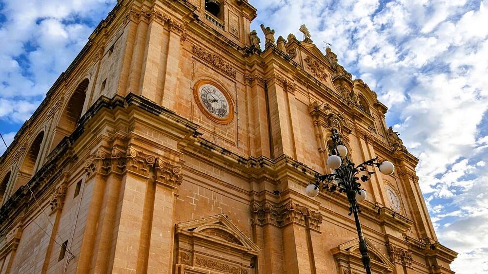 A large, ornate church with a clock tower and detailed facade.