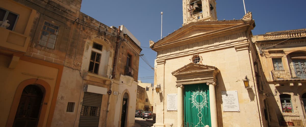 A historic building with a green door and a bell tower.