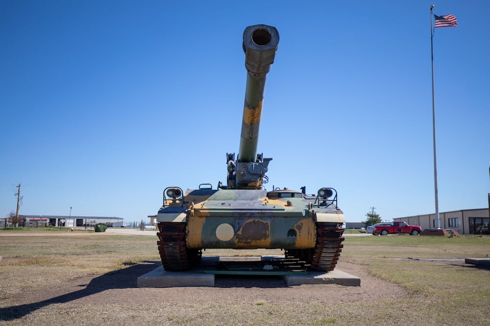 A military tank on display with an American flag in the background.